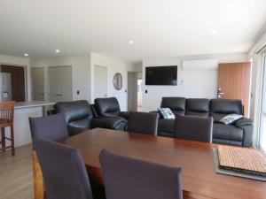 a living room with a couch and a table at Karikari Vista in Karikari Peninsula
