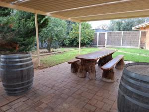a picnic table under a pavilion with two logs and two barrels at PAK House Central - Spacious 4 Bedroom New Listing! in Echuca