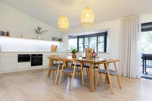 a kitchen and dining room with a wooden table and chairs at Surfside Retreat in Gnarabup