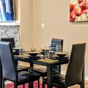 a black dining room table with chairs and glasses on it at Completely Modern Furnished Private House Near Mayo Clinic in Rochester