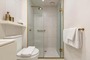 a bathroom with a shower and a toilet at Lavish Condo Prestigious St Kilda Rd Boulevard in Melbourne +33 photos