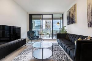 a living room with a couch and a table at Lavish Condo Prestigious St Kilda Rd Boulevard in Melbourne