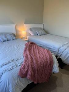 two beds sitting next to each other in a room at Smiths Place in Taupo