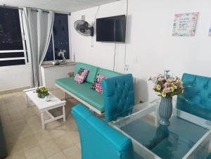 ein Wohnzimmer mit einem blauen Sofa und einer Vase mit Blumen in der Unterkunft Excelente vista al mar in Cartagena de Indias + 20 Fotos