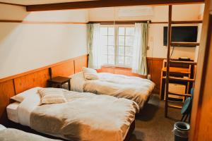 Postel nebo postele na pokoji v ubytování Hakuba Pension & Log Hotel Meteor