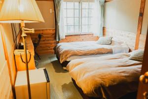 Postel nebo postele na pokoji v ubytování Hakuba Pension & Log Hotel Meteor