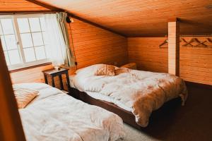 Postel nebo postele na pokoji v ubytování Hakuba Pension & Log Hotel Meteor
