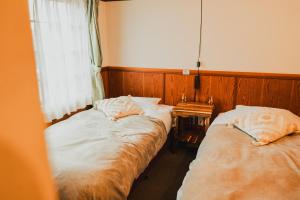 Postel nebo postele na pokoji v ubytování Hakuba Pension & Log Hotel Meteor