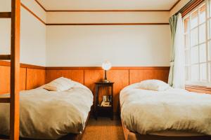Postel nebo postele na pokoji v ubytování Hakuba Pension & Log Hotel Meteor