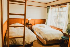 Postel nebo postele na pokoji v ubytování Hakuba Pension & Log Hotel Meteor