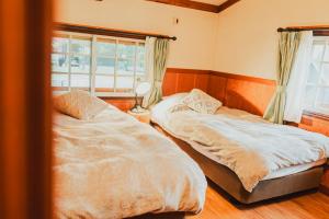 Postel nebo postele na pokoji v ubytování Hakuba Pension & Log Hotel Meteor
