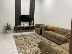 a living room with a couch and a tv at Homestay Bronizam 2 in Nilai