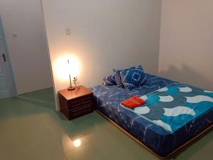 a bedroom with a bed and a lamp on a night stand at OIKOS GREEN - Homestay in Kuningan