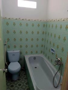 a bathroom with a toilet and a bath tub at OIKOS GREEN - Homestay in Kuningan