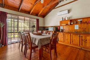 una cucina con un tavolo e sedie in una stanza di StayAU Cedar Lodge 3BR Quaint Countryside Cottage a Badger Creek