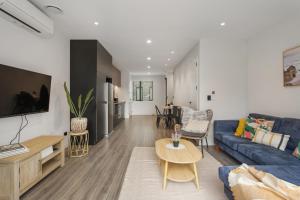 a living room with a blue couch and a table at Spring Special CBD Free Parking in Christchurch