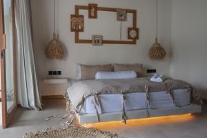 a bedroom with a bed and a mirror on the wall at Flora Villa Priv Pool By Yemaya in Kuta Lombok +25 photos