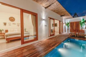 a villa with a pool and a bed and a bedroom at Senna Villa - 2BR with Private Pool in Canggu