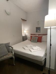 une chambre avec un lit, une lampe et une chaise dans l'établissement Happy Family Apartments Baia Boccadasse, à Gênes