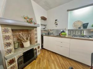 une cuisine avec des placards blancs et une cheminée dans l'établissement Happy Family Apartments Baia Boccadasse, à Gênes 16 autres photos