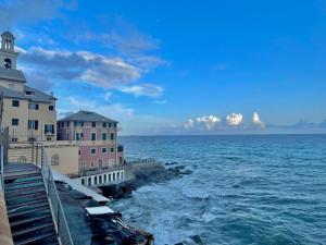 une vue sur l'océan avec des bâtiments et un phare dans l'établissement Happy Family Apartments Baia Boccadasse, à Gênes