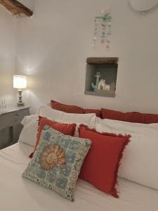 - une chambre avec 2 lits dotés d'oreillers rouges et blancs dans l'établissement Happy Family Apartments Baia Boccadasse, à Gênes