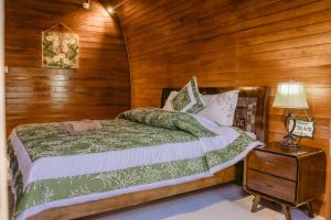 een slaapkamer met een bed en een houten wand bij Kubu Silvia in Nusa Dua