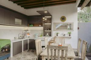 een keuken en eetkamer met een tafel en stoelen bij Kubu Silvia in Nusa Dua