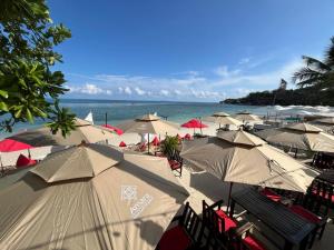 - un bouquet de parasols sur une plage avec l'océan dans l'établissement Amara Beach Resort Koh Phangan, à Haad Yao