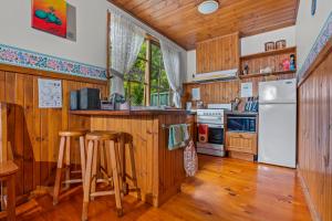una cucina con mobili in legno e un frigorifero bianco di StayAU Lakeview Cottage 2BR Cozy Nature Getaway a Badger Creek
