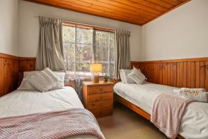 due letti in una stanza con finestra di StayAU Birchwood Cottage 2BR Yarra Valley Cottage a Badger Creek