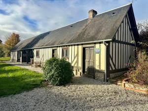 a house with a gambrel roof with a gravel driveway at La Soulterie in Crouttes