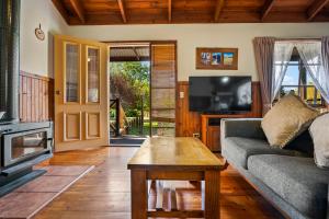 un soggiorno con un divano e un tavolino da caffè di StayAU Birchwood Cottage 2BR Yarra Valley Cottage a Badger Creek