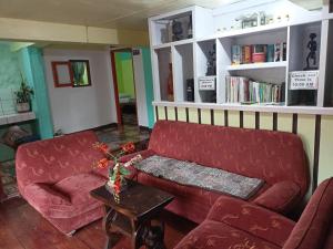 a living room with a red couch and a table at Las vegas lodge and restaurant in Banaue