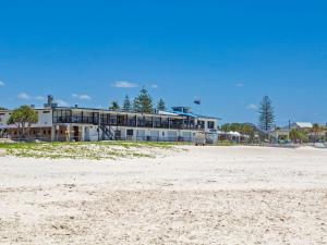 a building on the beach next to a sandy beach at Beached On Marine Parade in Kingscliff
