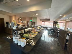 a buffet line in a restaurant with food on it at Hotel Route-Inn Iida in Iida