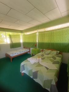 a green room with a bed and a couch at Huasai tours & lodge in Iquitos