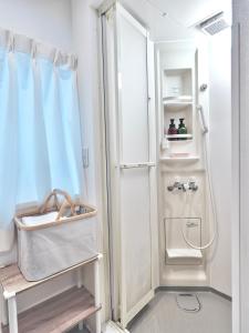 La salle de bains est pourvue d'une douche avec rideau de douche. dans l'établissement F House 青い海, à Osaka