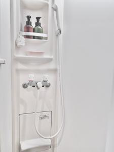 un réfrigérateur blanc avec un tuyau dans une pièce dans l'établissement F House 青い海, à Osaka