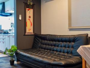 - un canapé en cuir dans une chambre avec cuisine dans l'établissement F House 青い海, à Osaka 28 autres photos