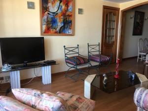 a living room with a flat screen tv and a couch at Depto Agua Marina vista al mar in La Serena