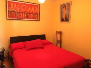 a red bed with red pillows in a bedroom at Depto Agua Marina vista al mar in La Serena