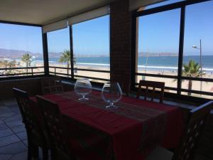 two wine glasses sitting on a table with a view of the beach at Depto Agua Marina vista al mar in La Serena