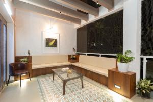a living room with a couch and a table and a window at Bauhinia in Pune