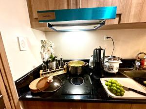 a kitchen with a stove top with some green grapes at High Rise Condo with Balcony, Pool, Grand Lobby,Gym and Sky Garden 22F in Manila