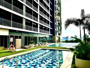 a swimming pool in front of a building at High Rise Condo with Balcony, Pool, Grand Lobby,Gym and Sky Garden 22F in Manila