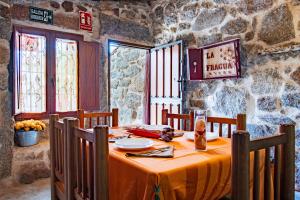 a table in a room with a stone wall at La Fragua in Villar de Corneja