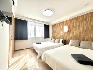 a hotel room with two beds and a television at Shinjuku-STS Hostel in Tokyo