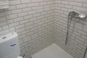 a white tiled bathroom with a toilet and a shower at Tangier city center 3 in Tangier