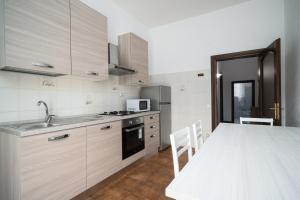 a kitchen with a sink and a table with chairs at Casa Picchereddu in Orosei +12 photos